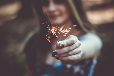 Close-up of woman holding sparkler
