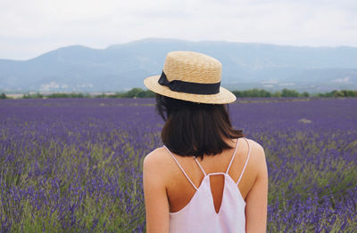 Rear view of woman with arms raised on field