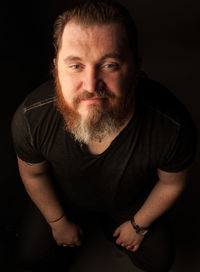 Portrait of young man against black background