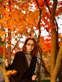 Portrait of young woman with autumn leaves