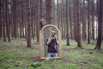 Man on tree trunk in forest