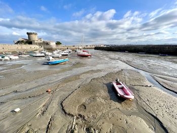 Boats moored on beach against sky