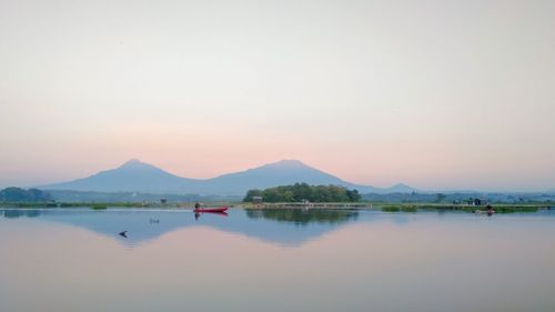 Scenic view of lake against clear sky during sunset