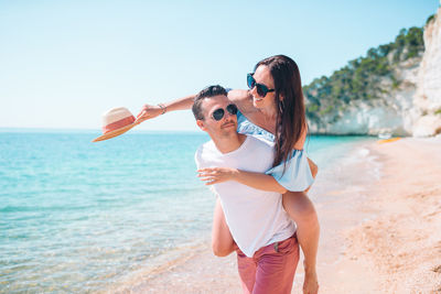 Low section of women standing on beach
