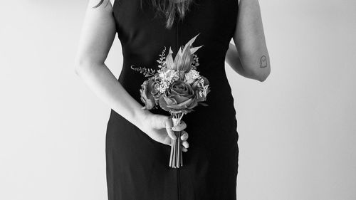 Midsection of woman holding umbrella against white background