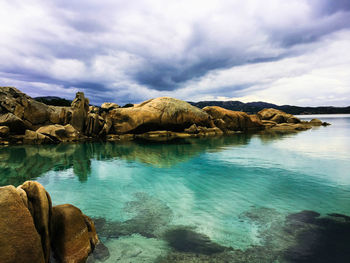 Rock formations by sea against sky