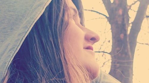 Close-up of young woman against tree
