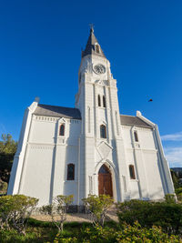 Low angle view of white dutch reformed church against blue sky, nieu-bethesda, south africa