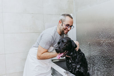 Man cleaning dog with water