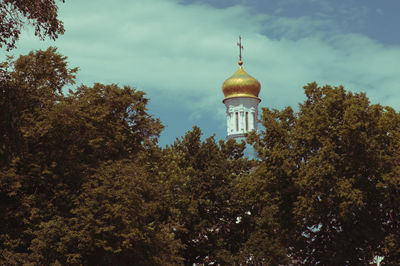 Low angle view of trees and building against sky