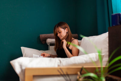 Portrait of a young woman sitting on bed