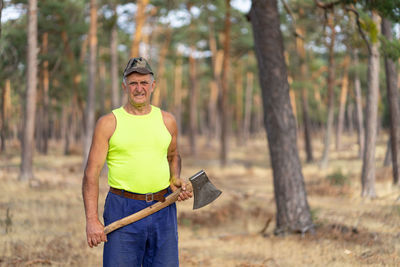 Portrait of man holding leaf in forest