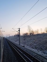 Railroad tracks against clear sky during winter