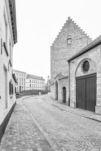 Footpath amidst buildings against sky