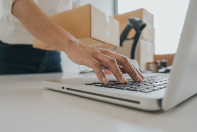 Midsection of man using laptop on table