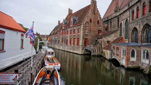 Panoramic view of people on boats in water against sky