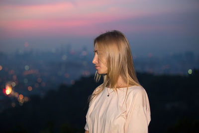 Young woman standing against sky at night