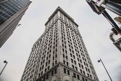 Low angle view of buildings against cloudy sky