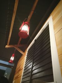 Low angle view of illuminated lighting equipment hanging from ceiling