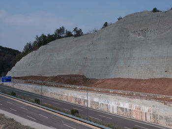 Road leading towards mountain against sky