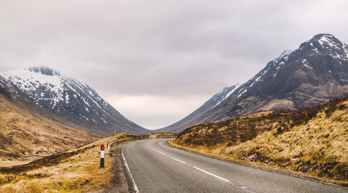 Road amidst mountains against sky