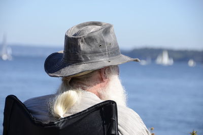 Rear view of woman by sea against sky