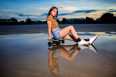 Asian women playing surf skate or skates board outdoors.