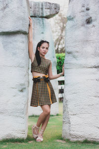 Full length portrait of woman standing amidst rocks