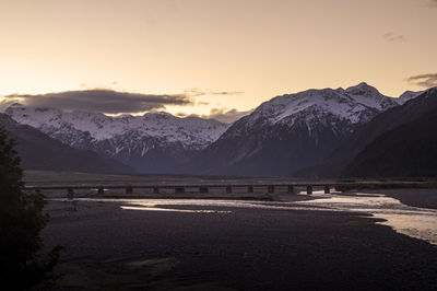 Scenic view of snowcapped mountains against sky during sunset