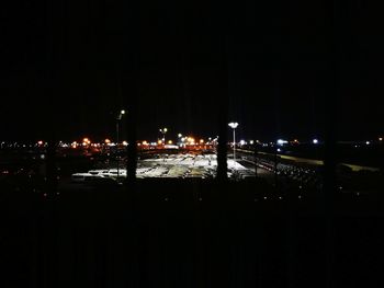 Illuminated street amidst buildings in city at night