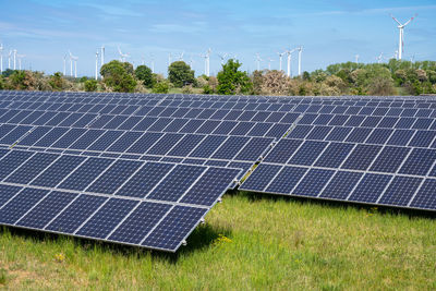 Solar panels with wind turbines in the back seen in germany