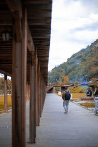 Rear view of man walking on road