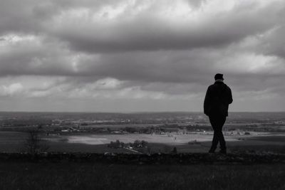 Man walking at beach against sky