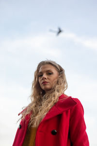 Portrait of teenage girl standing against sky