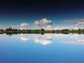 Scenic view of lake by buildings against blue sky