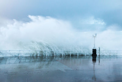 Scenic view of wave splashing  against sky during rainy season