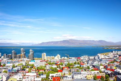 High angle view of cityscape by sea against sky