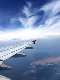 Aerial view of airplane wing against cloudy sky