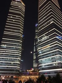 Low angle view of illuminated buildings against sky at night