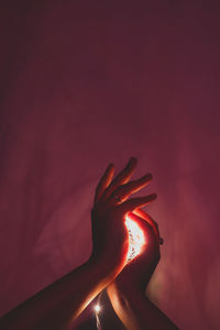 Close-up of hand touching red wall