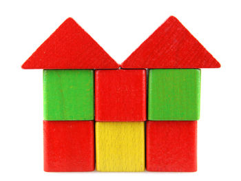 Stack of model house made from toy blocks on playground