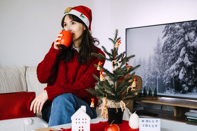Portrait of young woman sitting on sofa at home