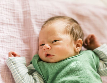 Portrait of cute baby lying on bed