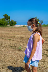 Full length of girl on field against blue sky