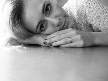 Close-up portrait of woman resting on table at home