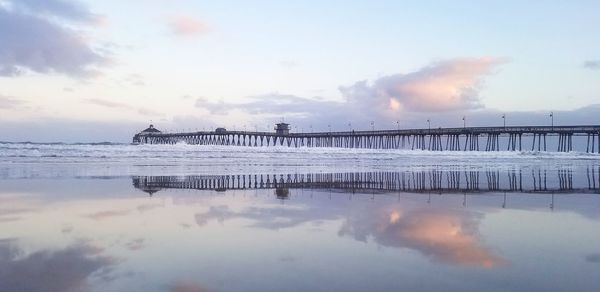 Bridge over sea against sky during sunset