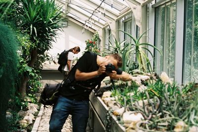 Full length of photographer photographing plants