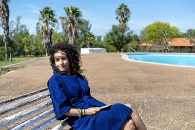 Portrait of young woman sitting on road