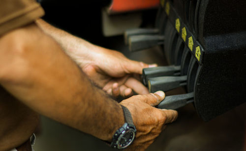 Midsection of man operating machinery in factory