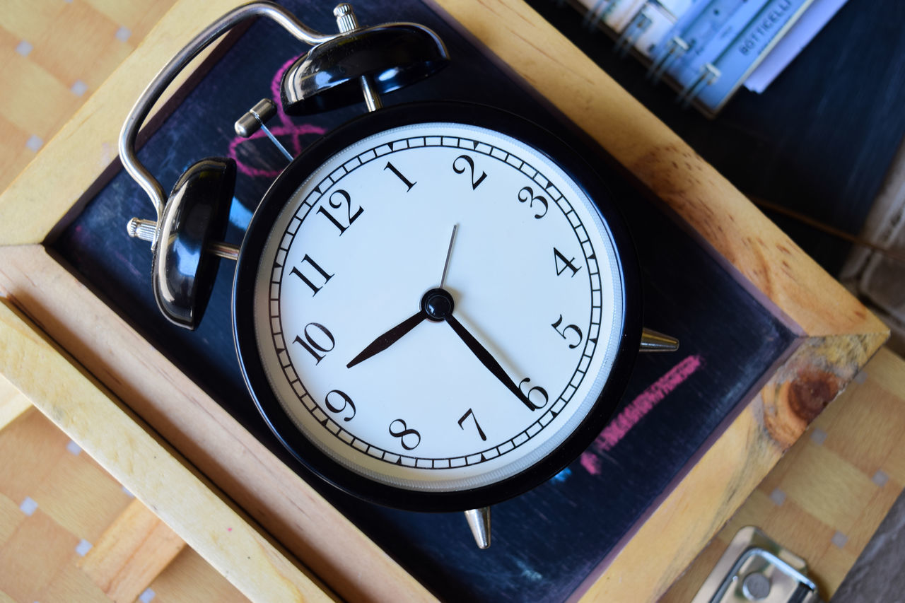 HIGH ANGLE VIEW OF CLOCK ON TABLE IN MIRROR